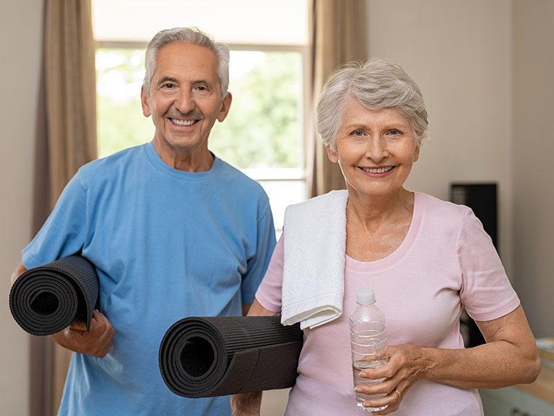 elderly couple with yoga mats